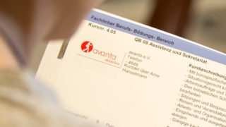 Eine Person schaut in den AbA-Katalog der WKM