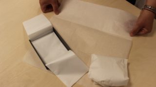Eine Person verpackt etwas in Papier