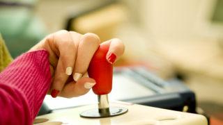 Eine Person bedient mit der Hand eine Joystick-Mouse