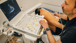 Ein Arzt führt eine Ultraschall-Untersuchung bei einem Patienten durch