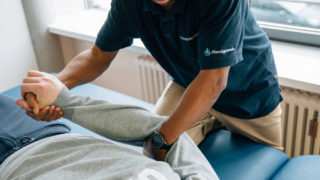 Therapeut mit Patient in der Physiotherapie der Pfennigparade