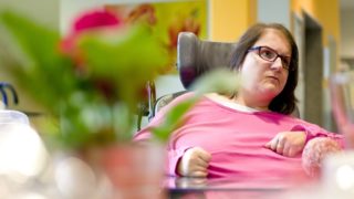 Eine junge Frau sitzt im Elektrorollsuhl