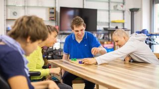Vier junge Menschen spielen an einem Tisch