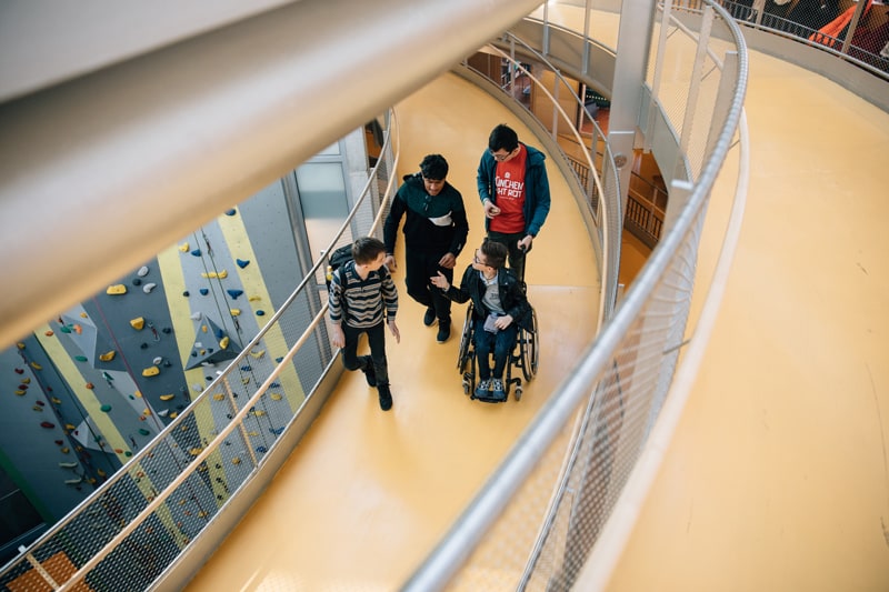 Vier Schüler*innen stehen auf dem Rondell der Ernst-Barlach-Schulen, eine davon sitzt im Rollstuhl