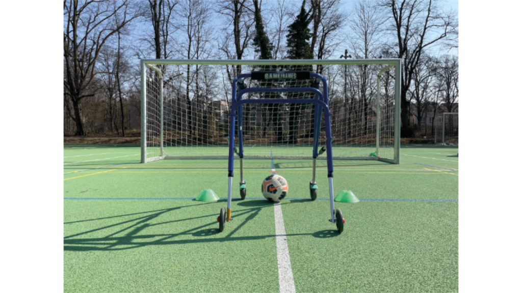 Framerunner mit Fußball auf dem Sportplatz