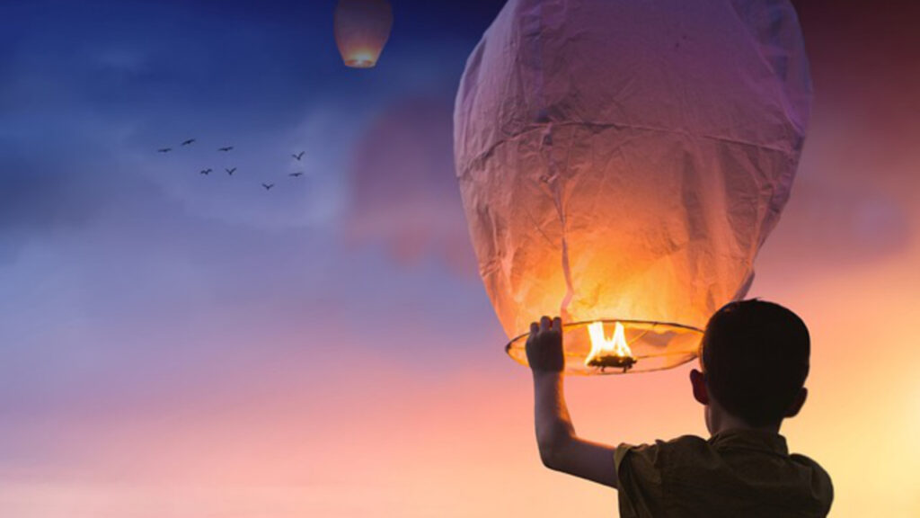 Mann hat Heißluftballon in den Händen