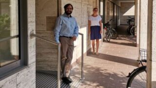 Ein Mann und eine Frau stehen vor einem Gebäude