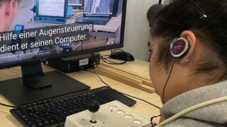 Frau mit Kopfhörer und Joystick Mouse beim Untertiteln eines Videos