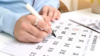 Person markiert Kalenderblatt mit Stift