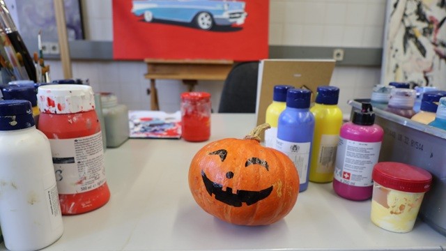 Kürbis neben verschiedenen Farben auf einem Tisch