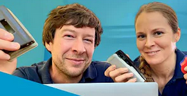 Zwei Personen nebeneinander haben Locher in der Hand