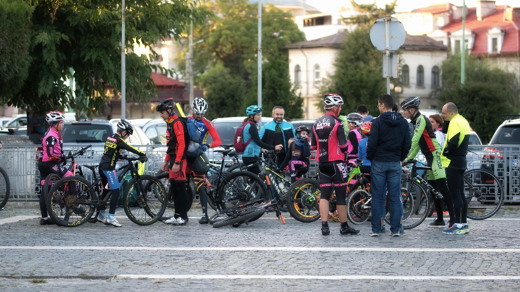 Viele Personen mit Helm und Fahrrädern auf dem Parkplatz