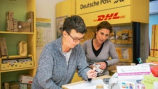 Zwei Personen bei der Arbeit in der Postpartnerfiliale